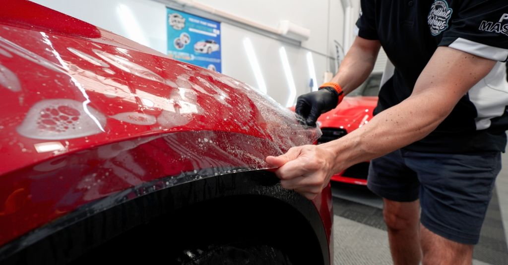 Radikal Wraps applying paint protection film on a Tesla, showcasing expertise in PPF maintenance and tailored paint protection